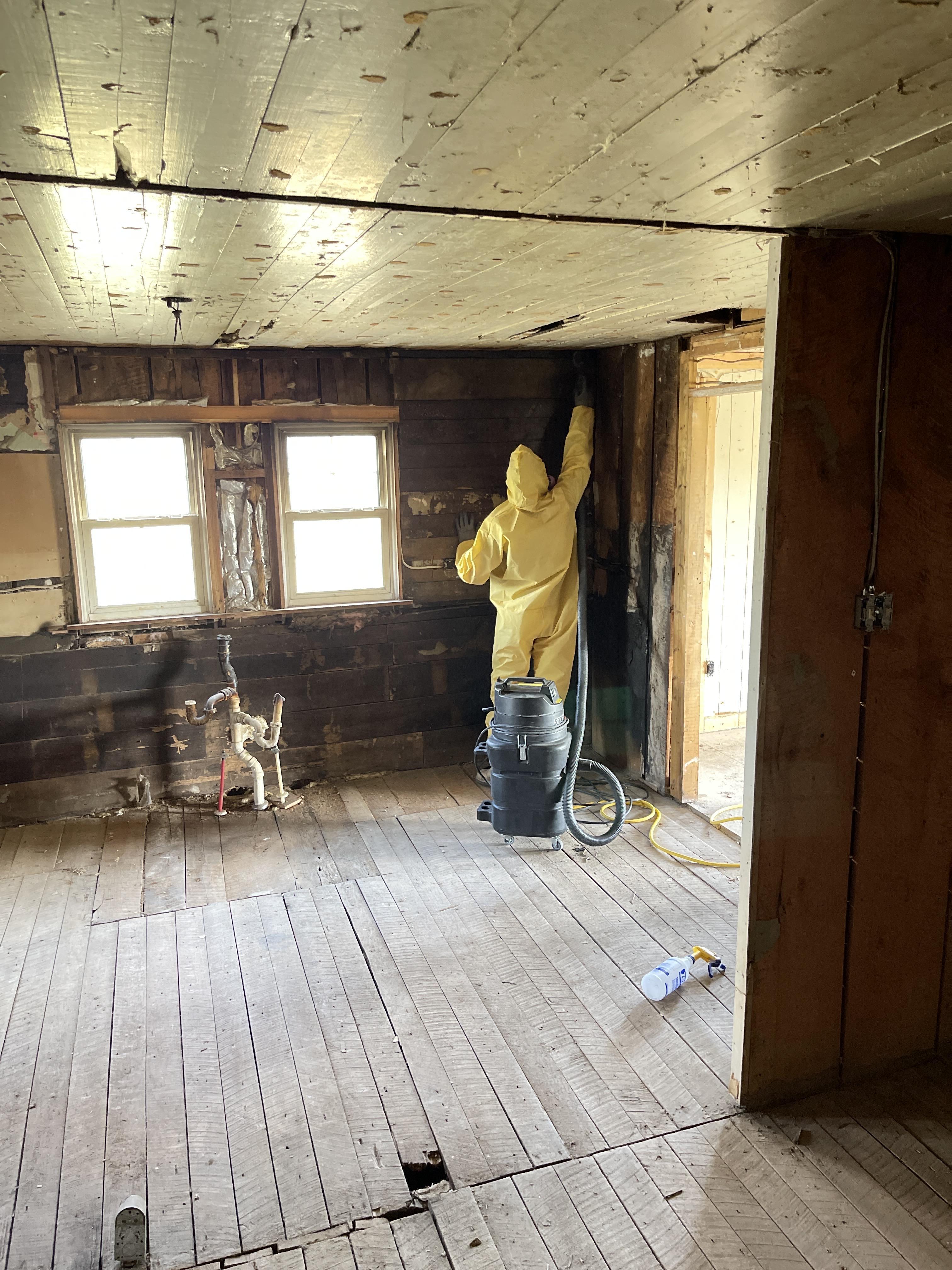 IRS technician in yellow hazmat suit cleaning a contaminated ceiling in Las Vegas